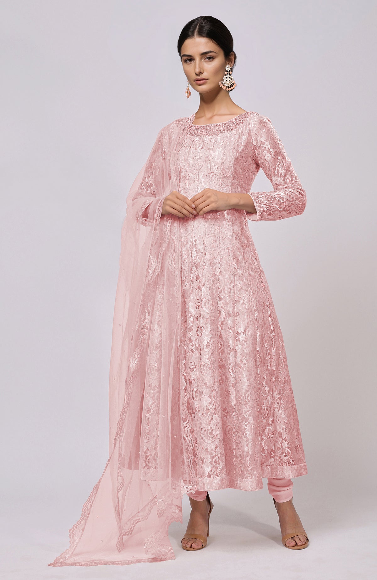 A woman models a pink lace Anarkali set with a matching dupatta and churidar.