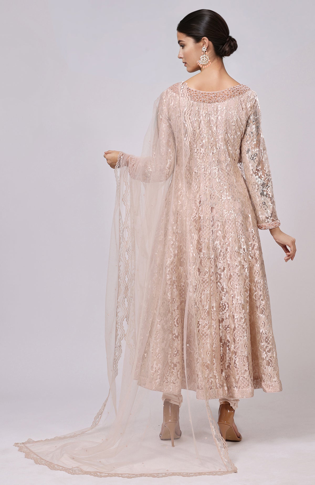 A woman models a champagne lace anarkali set with a matching dupatta.
