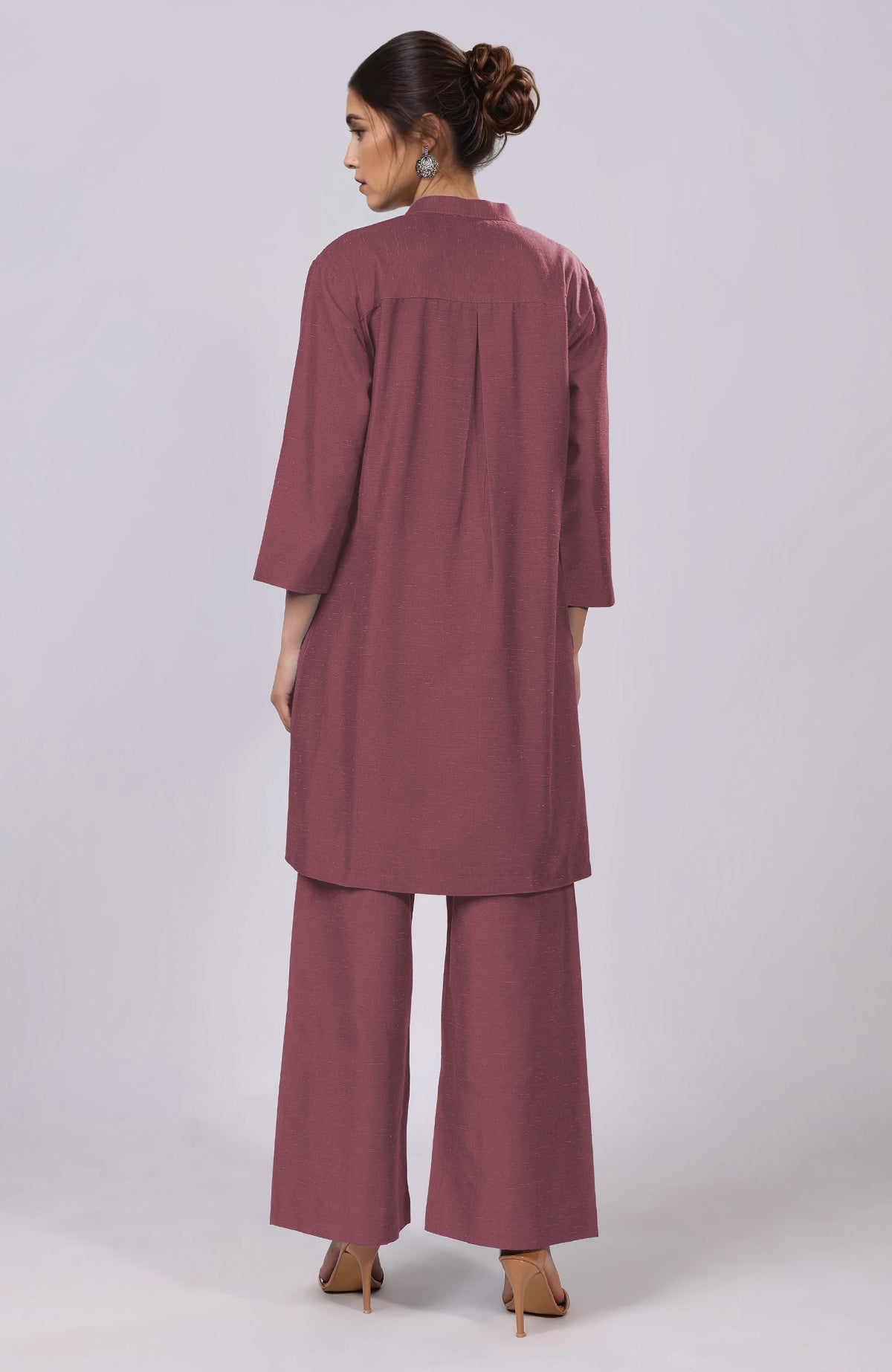 A woman from behind wears a maroon co-ord set with a tunic and wide-leg pants.