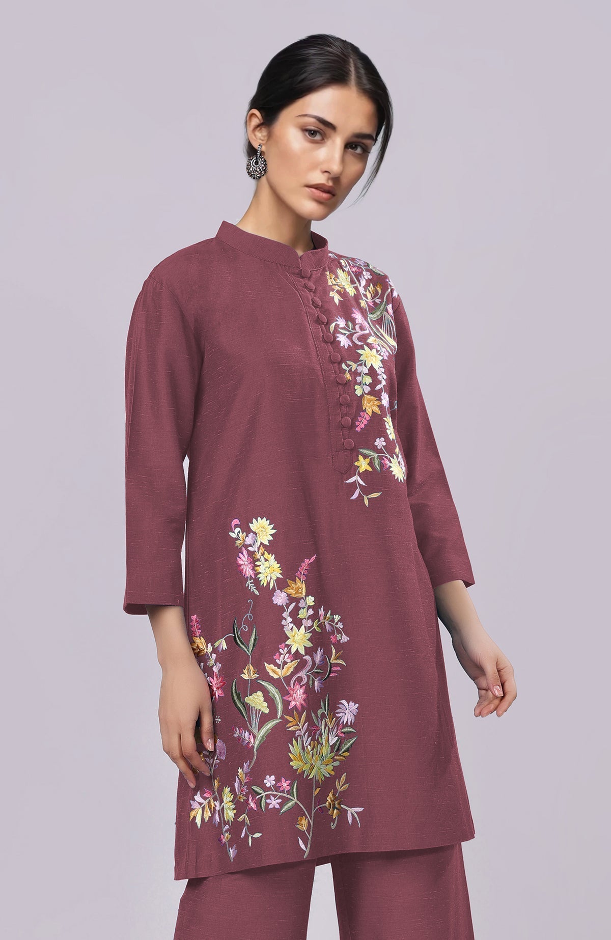 A woman models a maroon Parsi Gara embroidered co-ord set with a band collar.
