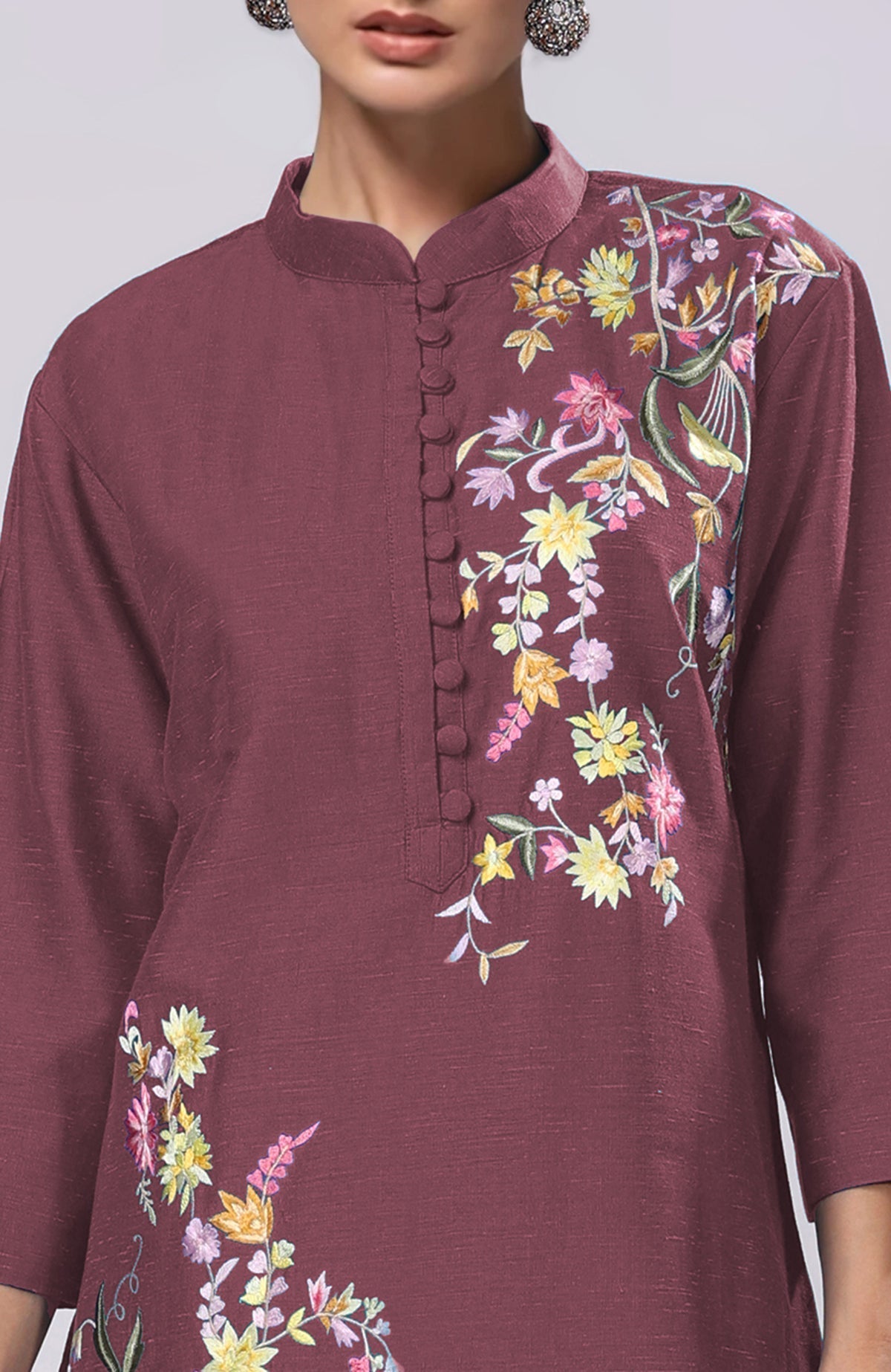 A woman wears a maroon Parsi Gara embroidered co-ord set with a band collar.