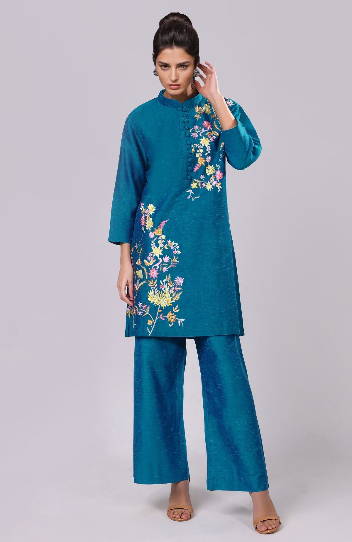 A woman models a teal Parsi Gara embroidered co-ord set with wide-leg pants.