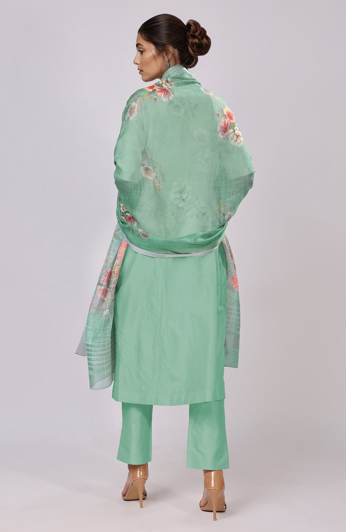 A woman from behind wears a dusty jade green floral linen dupatta and suit.