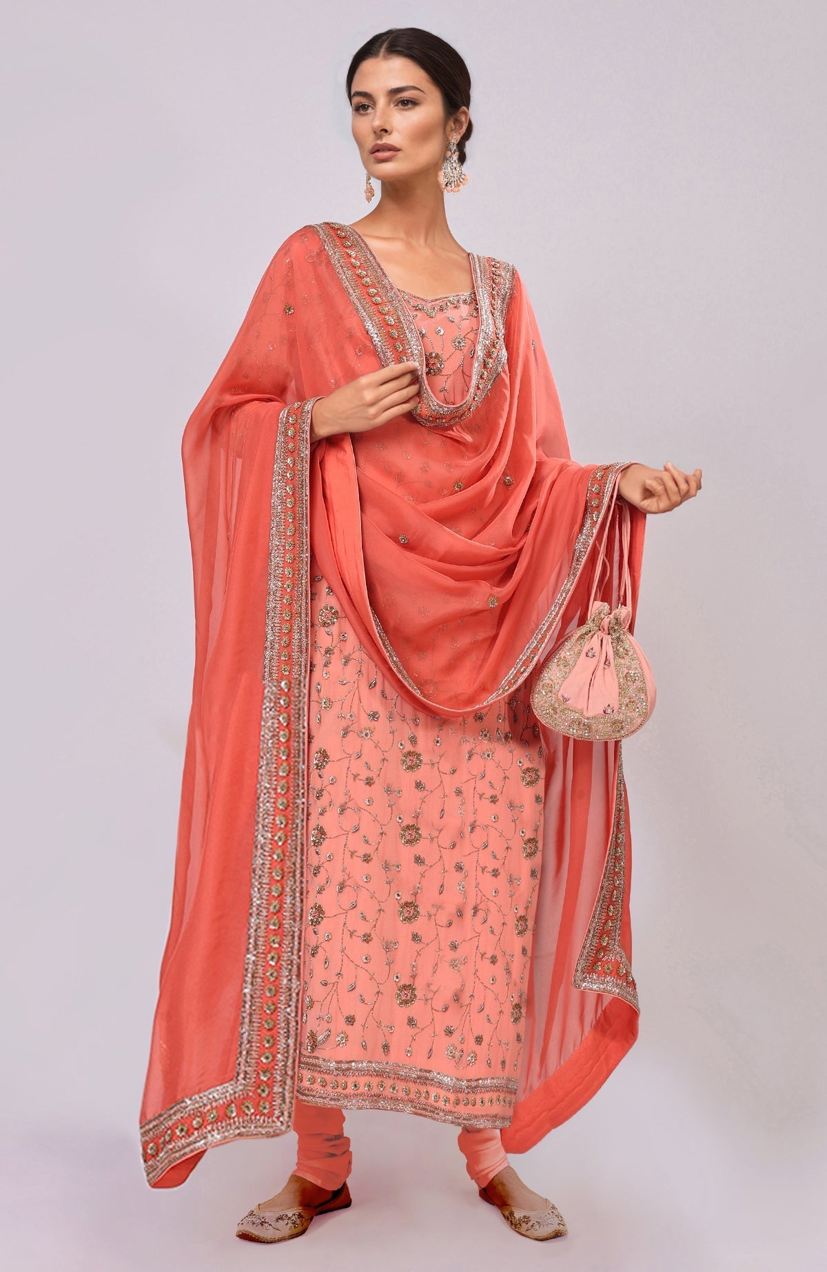 A woman models a salmon dabka and zardozi hand-embroidered kurta set.