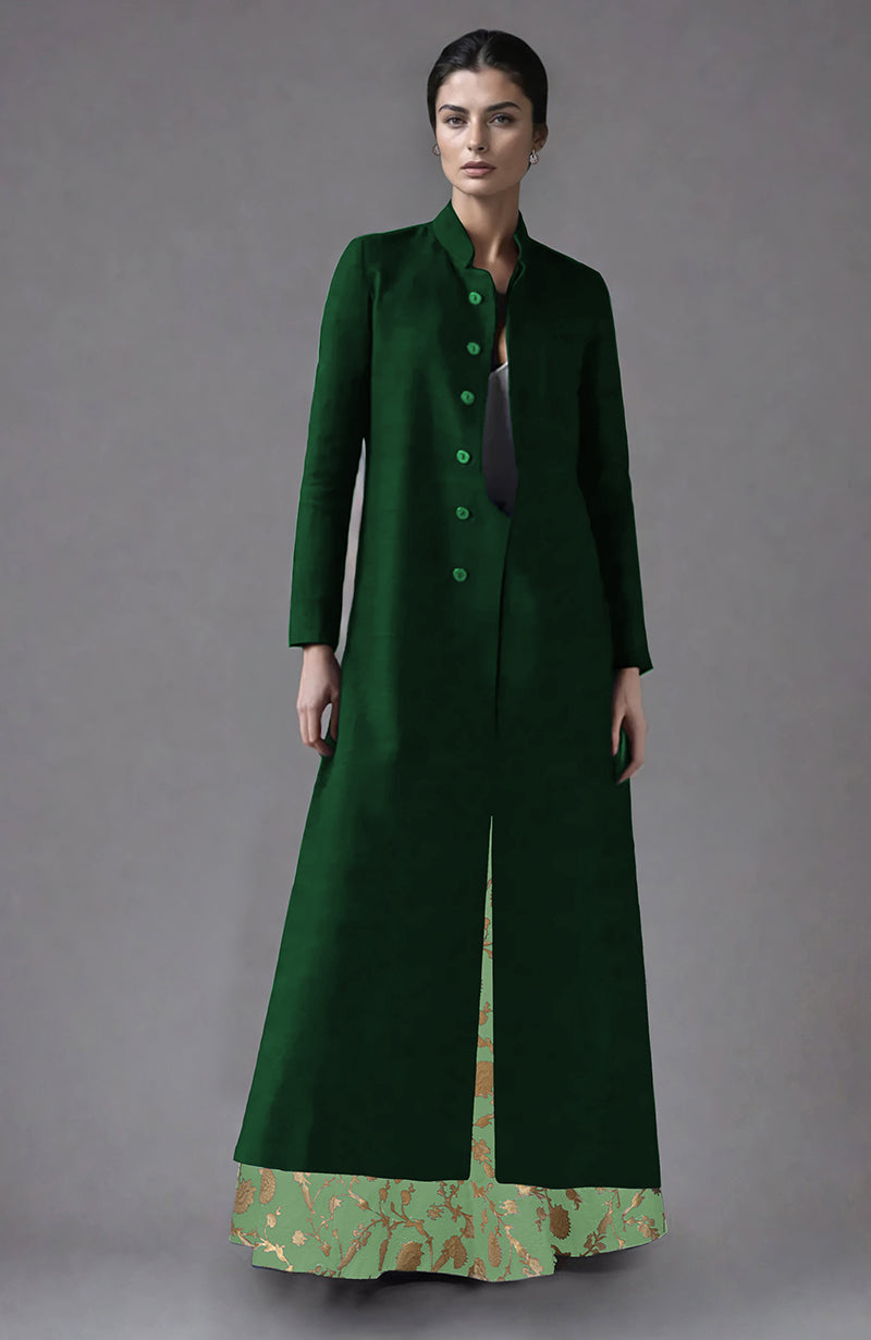 A woman models a dark green raw silk jacket with a light green brocade skirt.