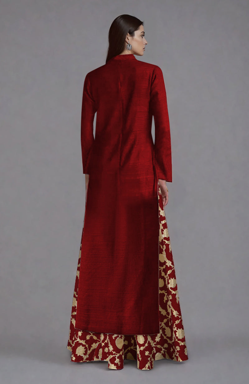 A woman models a red raw silk jacket with a gold brocade skirt from the back.
