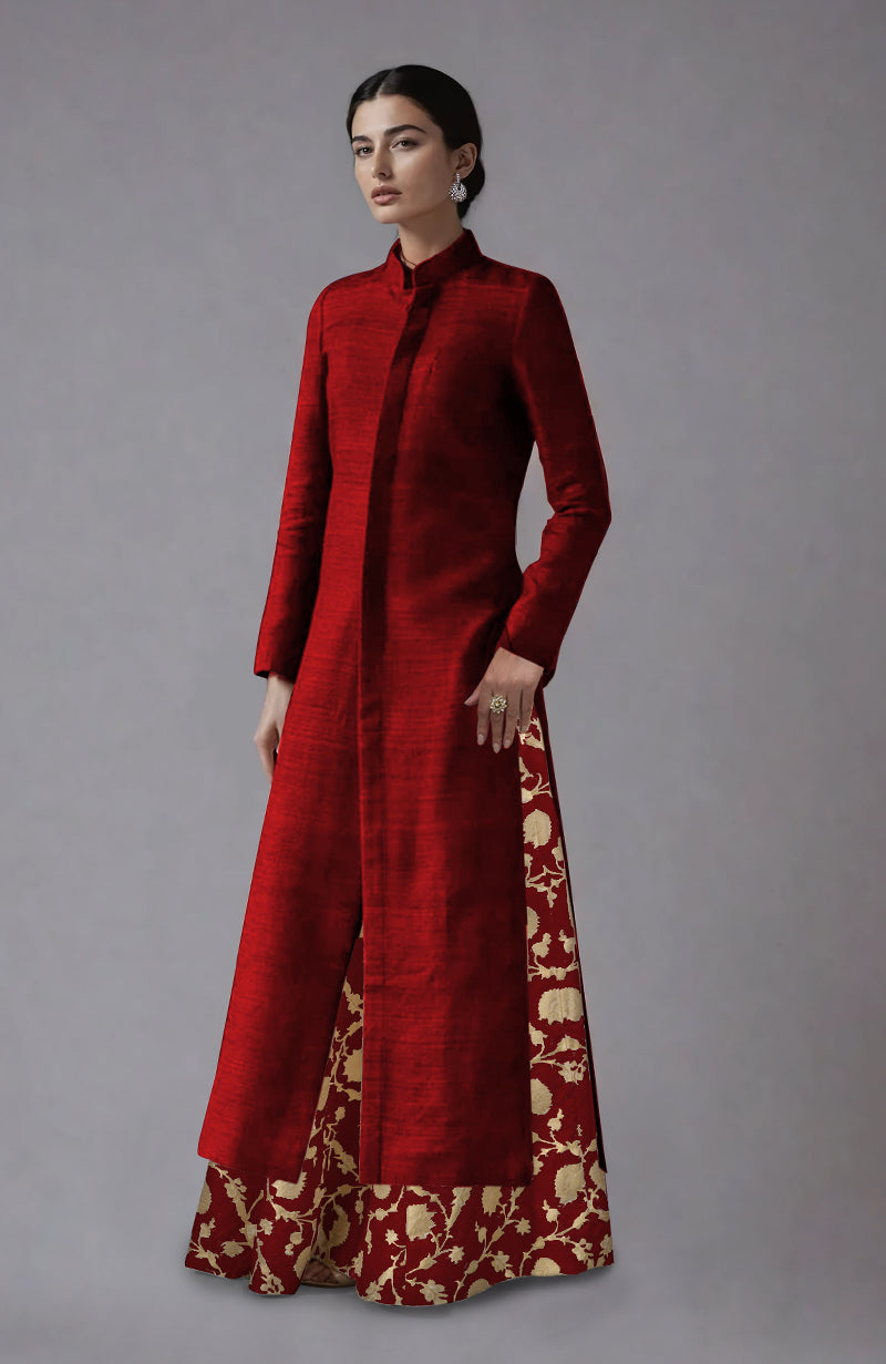 A woman models a red raw silk jacket with a matching brocade skirt.