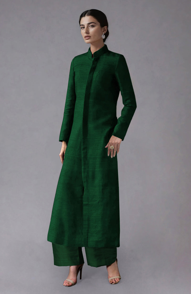 A woman models a dark green raw silk jacket with a band collar and matching wide-leg pants.