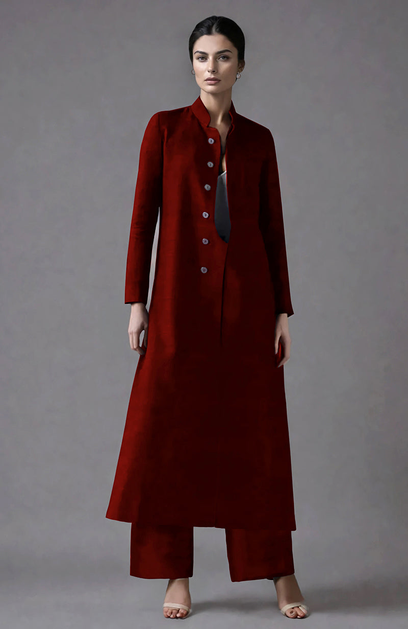 A woman models an emerald green raw silk jacket set with wide-leg pants.