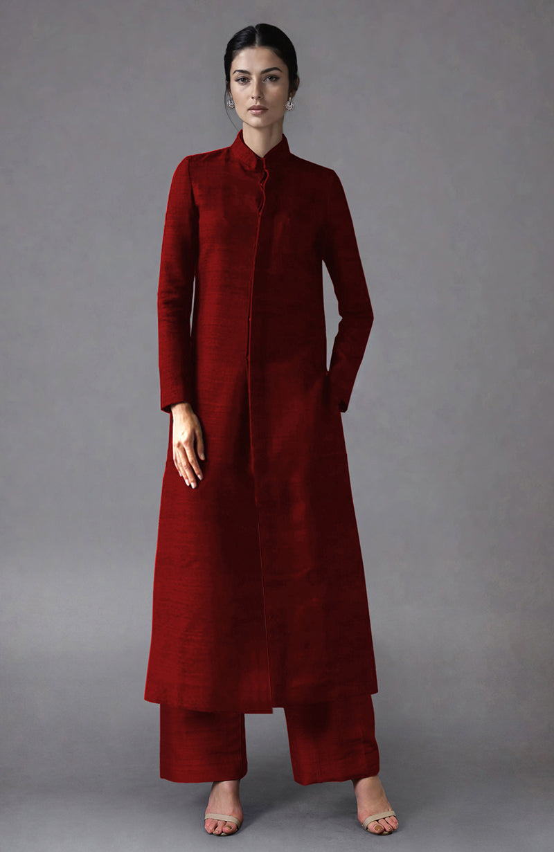 A woman models a red raw silk jacket set with a long jacket and wide-leg pants.