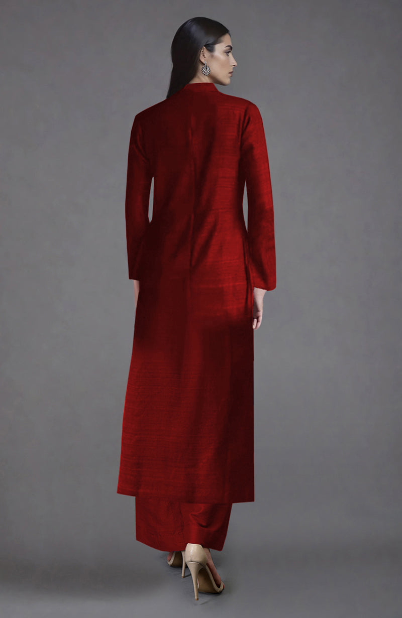 A woman from the back wears a red raw silk jacket with wide-leg pants and nude heels.