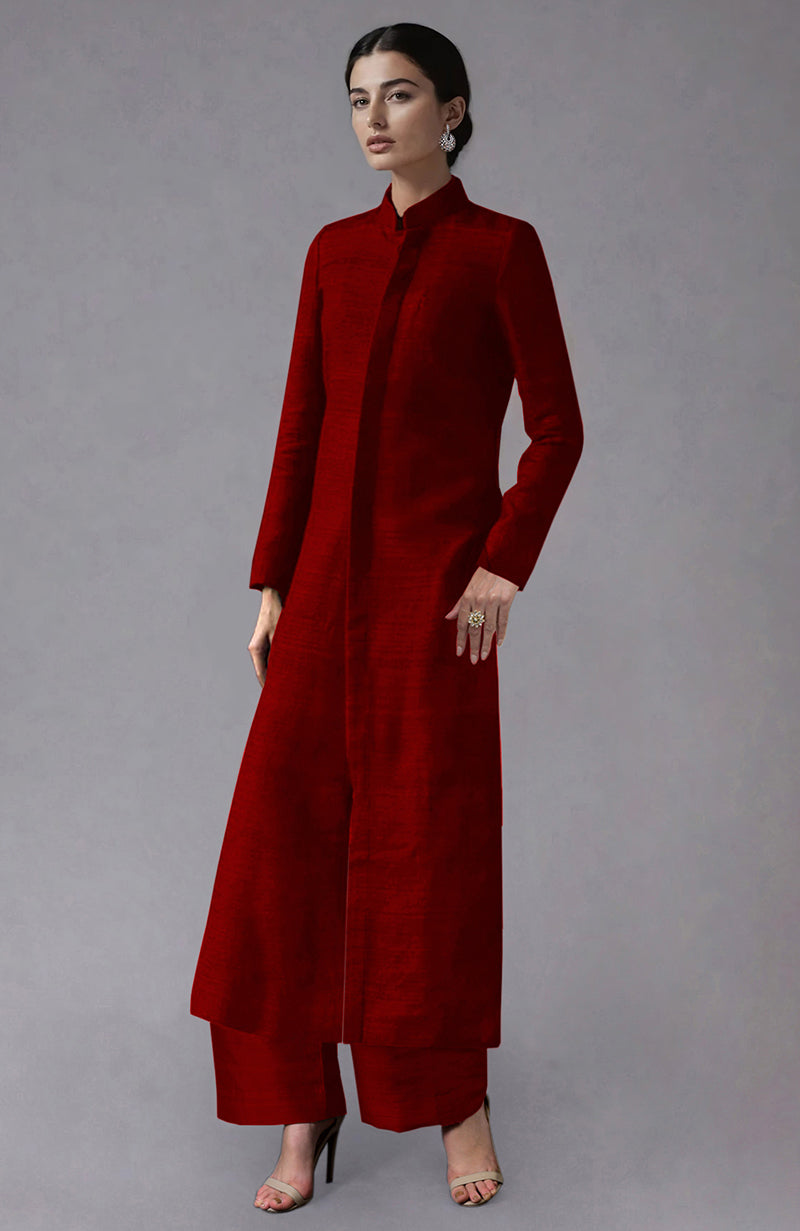 A woman models a red raw silk jacket with a band collar and wide-leg pants.