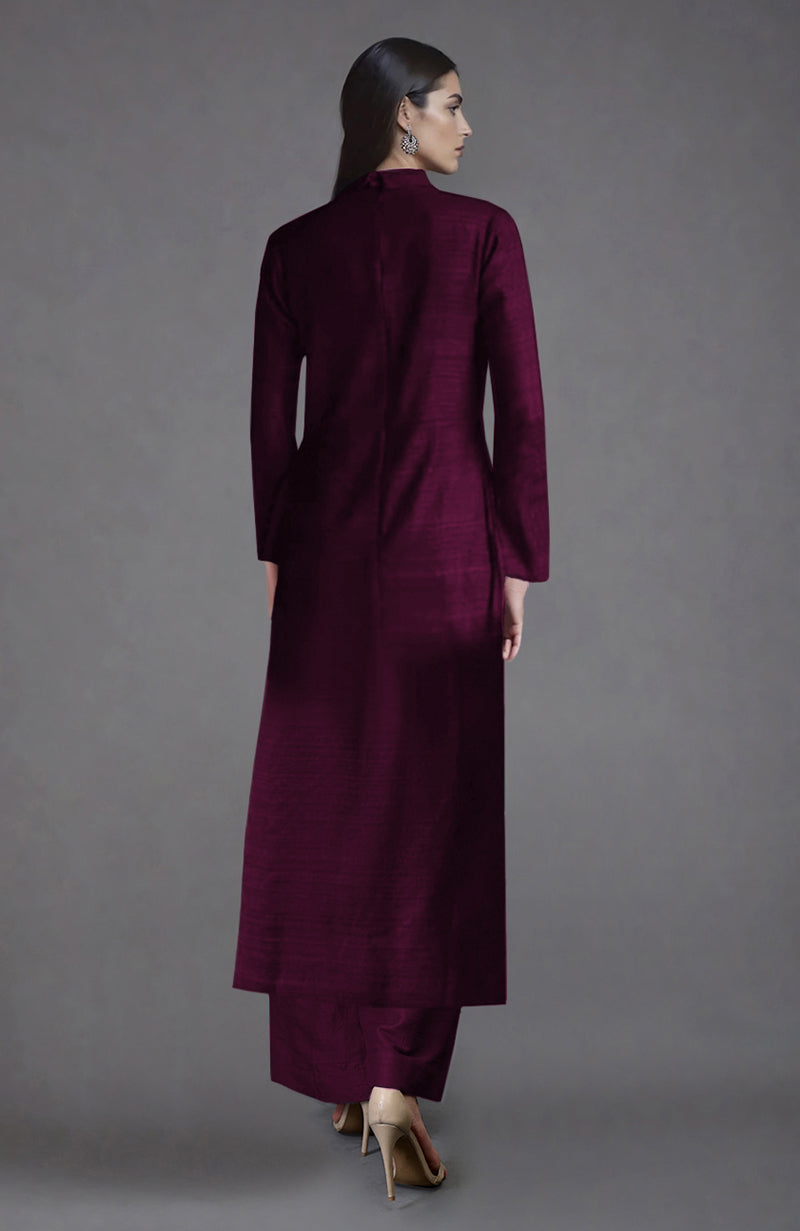 Woman in a wine raw silk jacket set with wide-leg pants and heels, viewed from behind.
