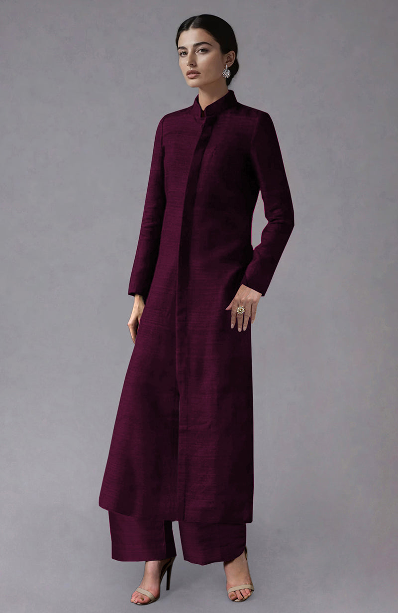 A woman models a wine raw silk jacket set with a band collar and wide-leg pants.