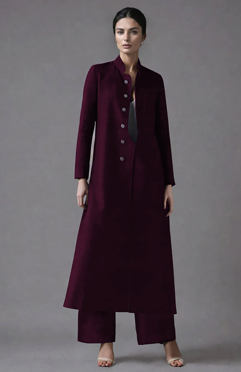 A woman models a wine raw silk jacket set with a band collar and wide-leg pants.