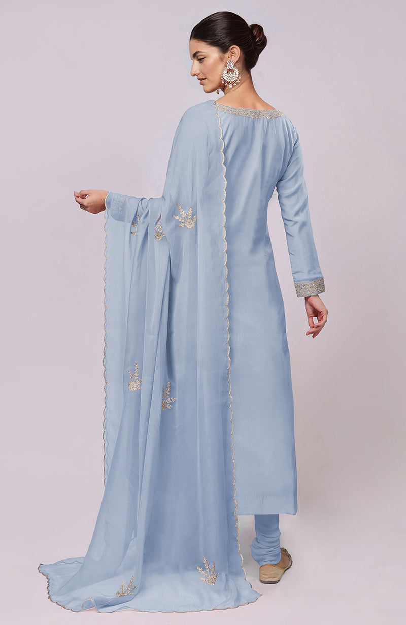 A woman models a dusty blue Kashmiri Tilla Aari embroidered kurta set.