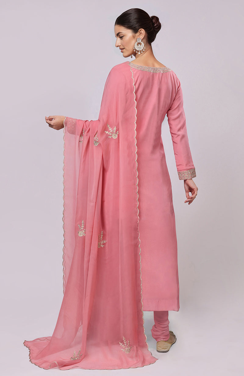 A woman models a pink Kashmiri Tilla Aari embroidered kurta set with a matching dupatta.