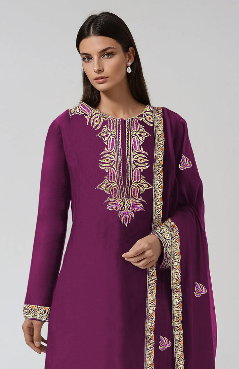 A woman models a peacock pink Kashmiri kurta set with intricate tilla and resham embroidery.