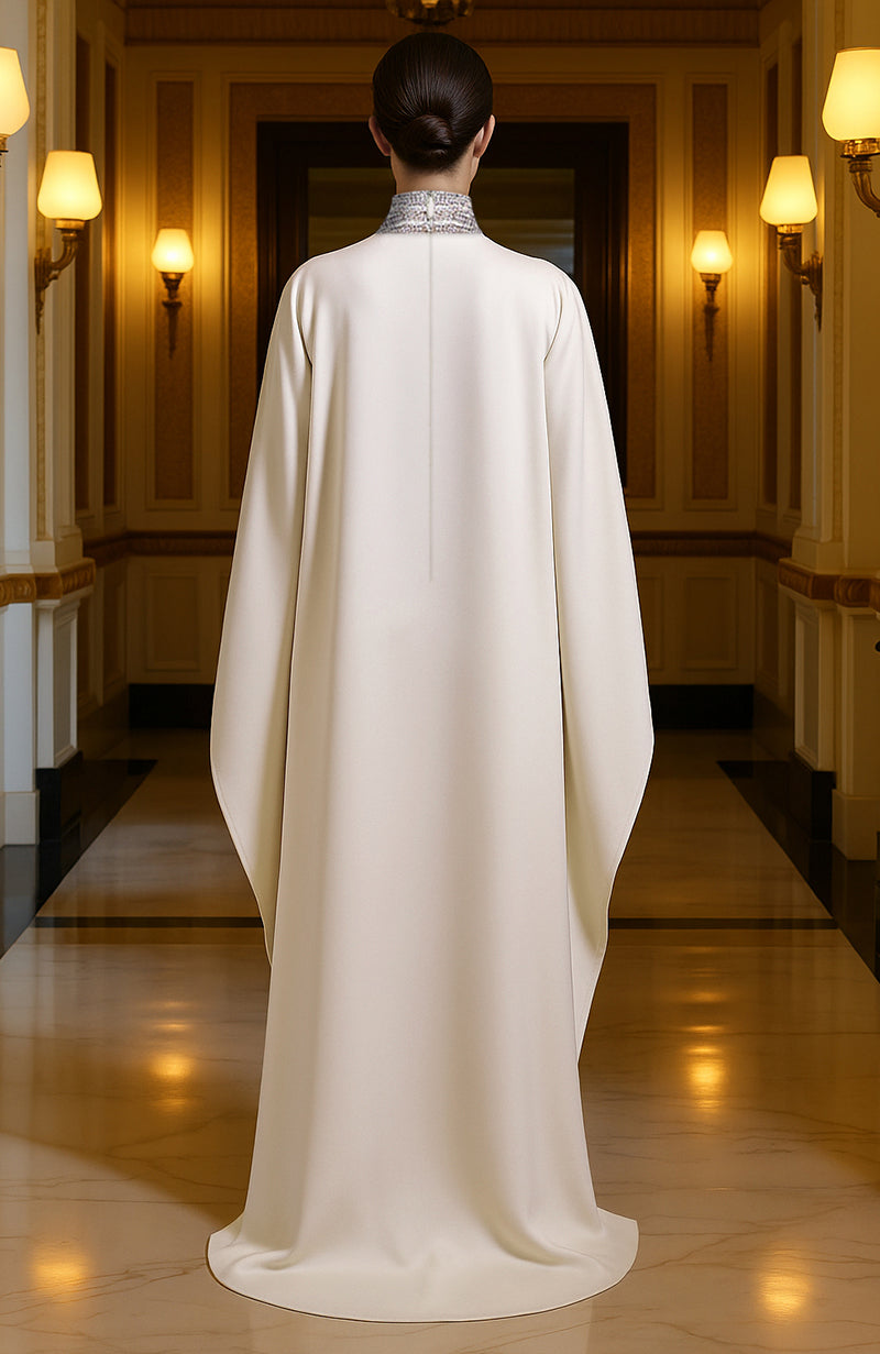 Ivory floor-length gown with bead and crystal embroidery, high neckline, and wide sleeves.