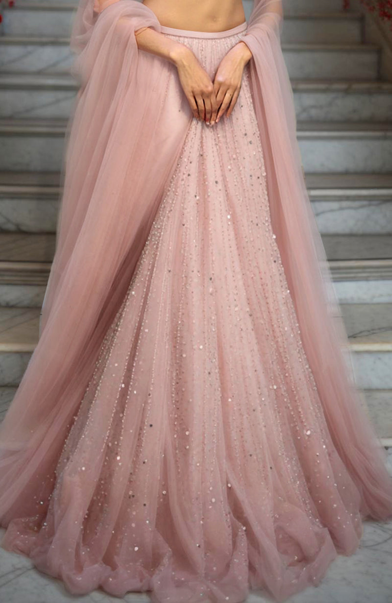 Blush pink lehenga set with embroidered high-neck blouse, voluminous tulle skirt, and sheer dupatta.
