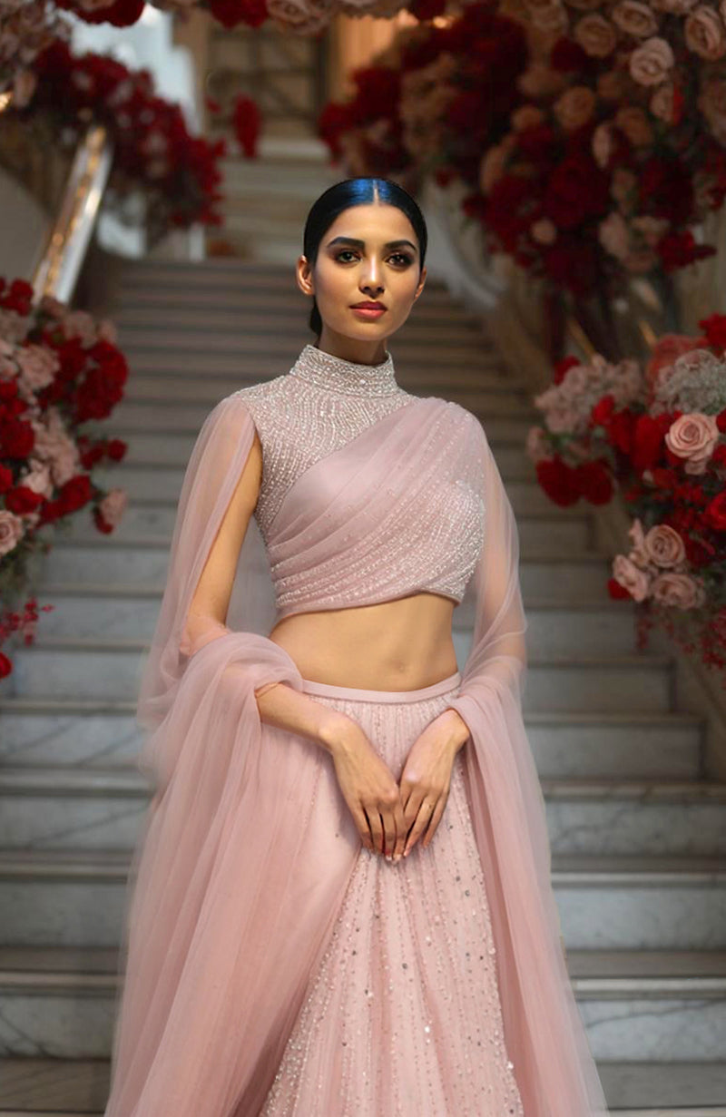 Blush pink lehenga set with embroidered high-neck blouse, voluminous tulle skirt, and sheer dupatta.