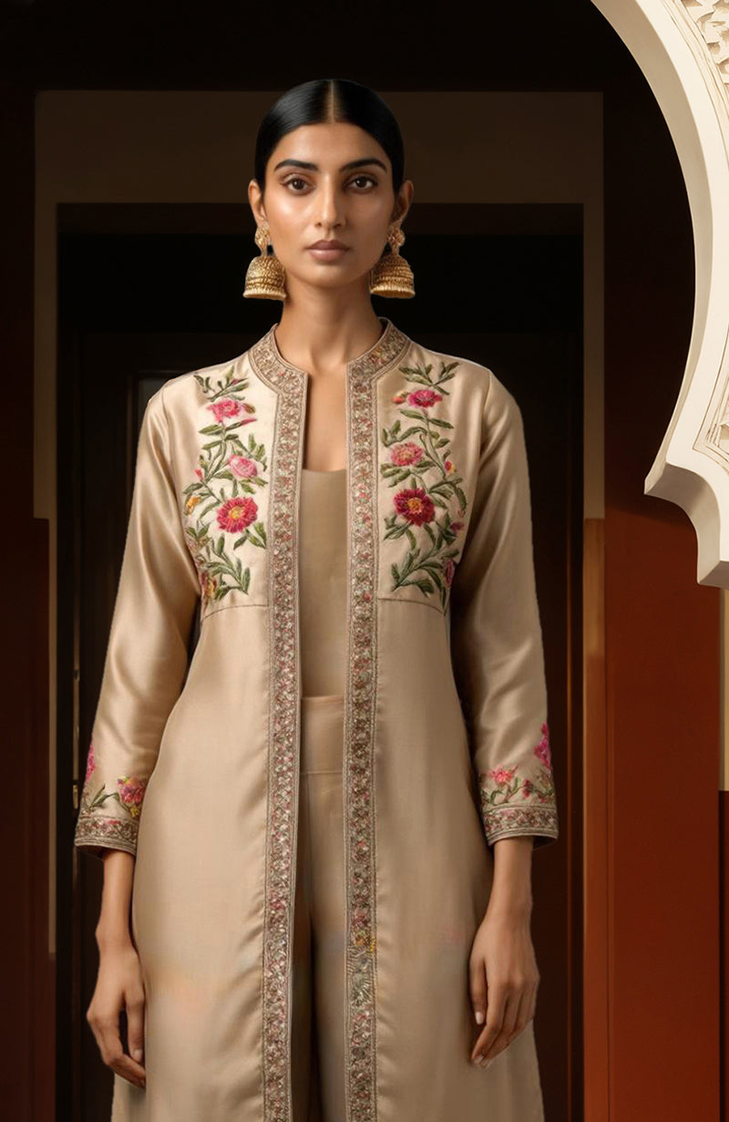 Beige long jacket with pink and green floral embroidery, matching wide-leg trousers, and camisole top.
