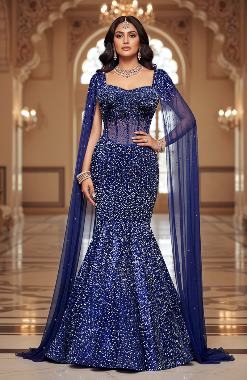 A blue embroidered corset lehenga set with a dramatic mermaid silhouette and sequined cape.