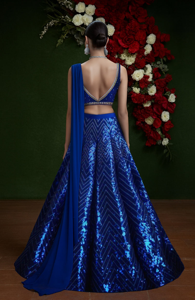 Blue lehenga set with sequin and bead embroidery, deep V-neck blouse, and sheer dupatta.