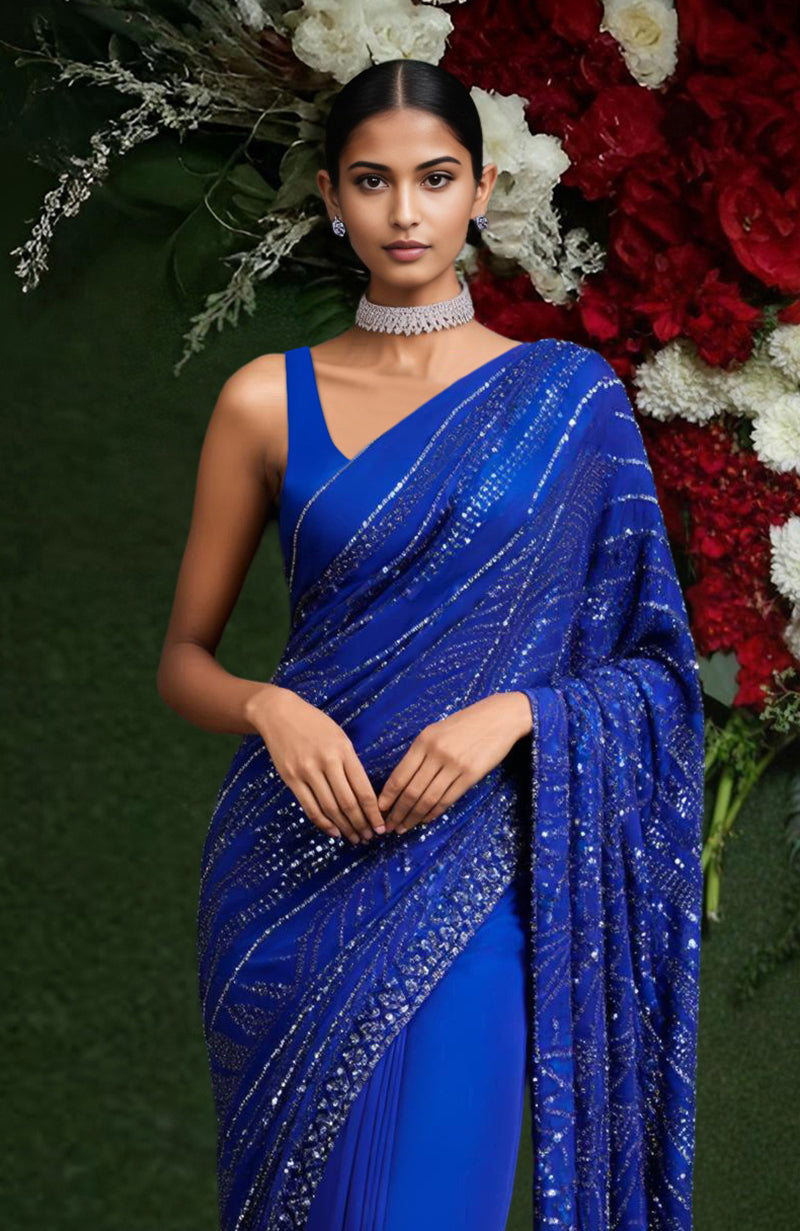 Deep blue saree with sequin and bead embroidery in star-like geometric patterns and a draped pallu.