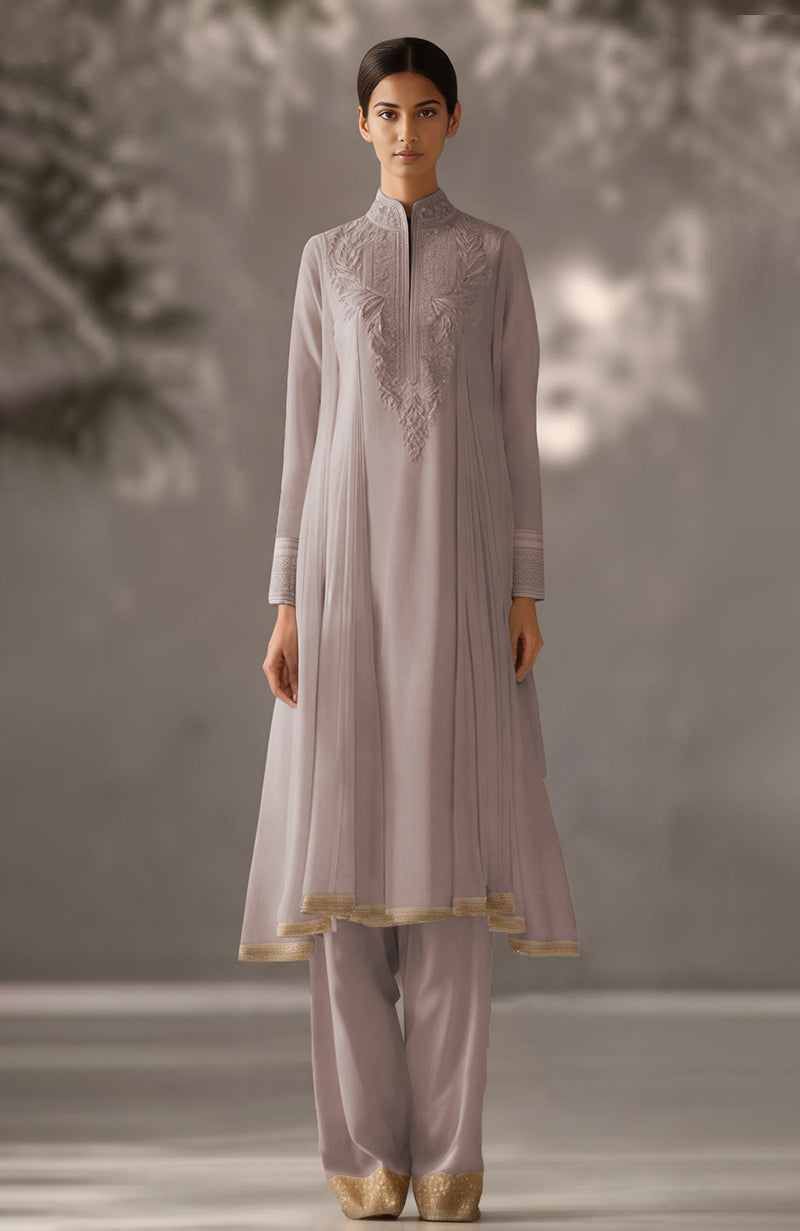 Soft ivory kurta set with floral embroidery, pleated drape design, and gold-embellished trousers