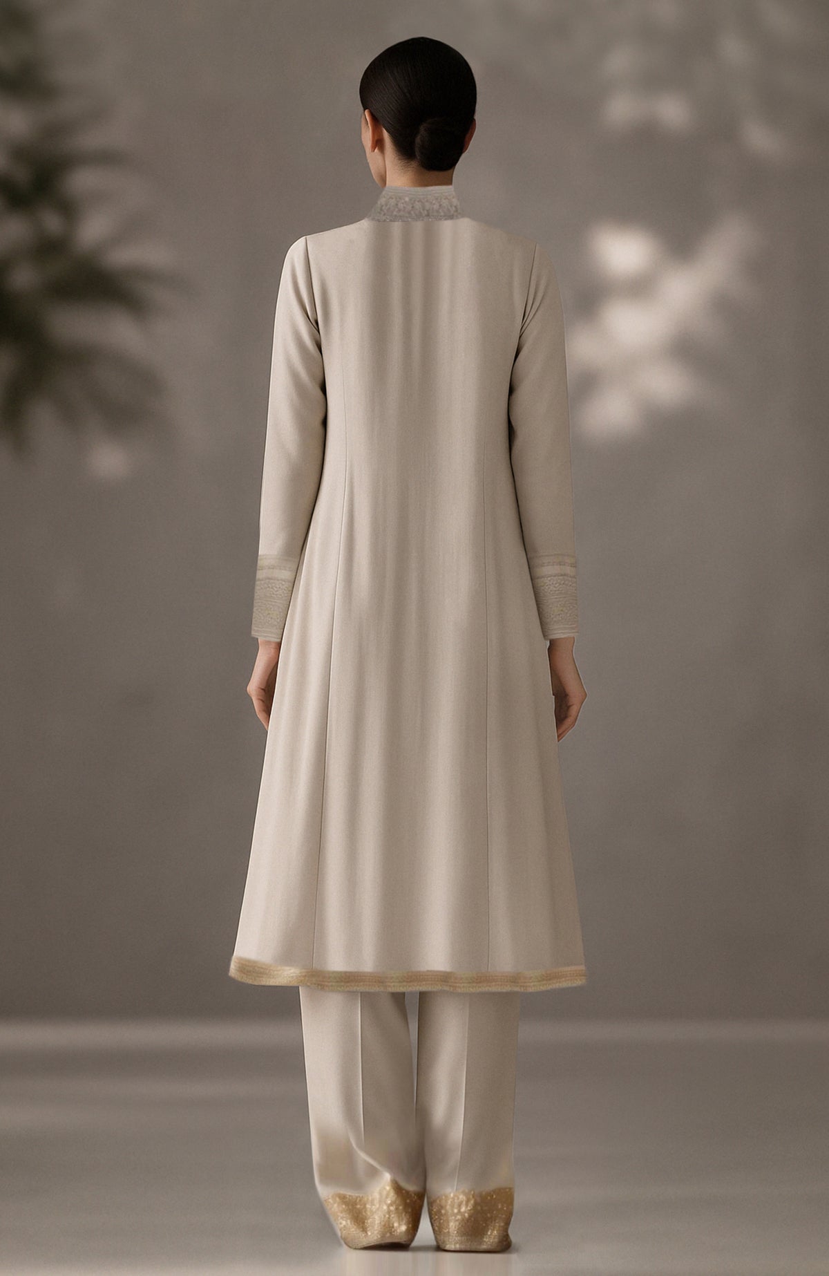 Soft ivory kurta set with floral embroidery, pleated drape detail, and gold-embellished trousers.