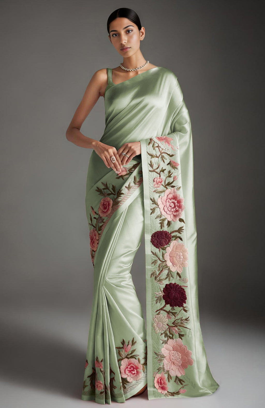 Sage green saree with embroidered peonies and roses in pink, burgundy, and ivory tones.