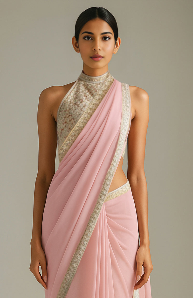 Blush pink saree with floral motifs and embroidered halter-neck blouse in gold and ivory tones