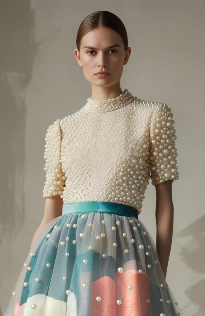 Teal floral skirt with sheer pearl-embellished overlay and pearl-embroidered fitted top with short sleeves