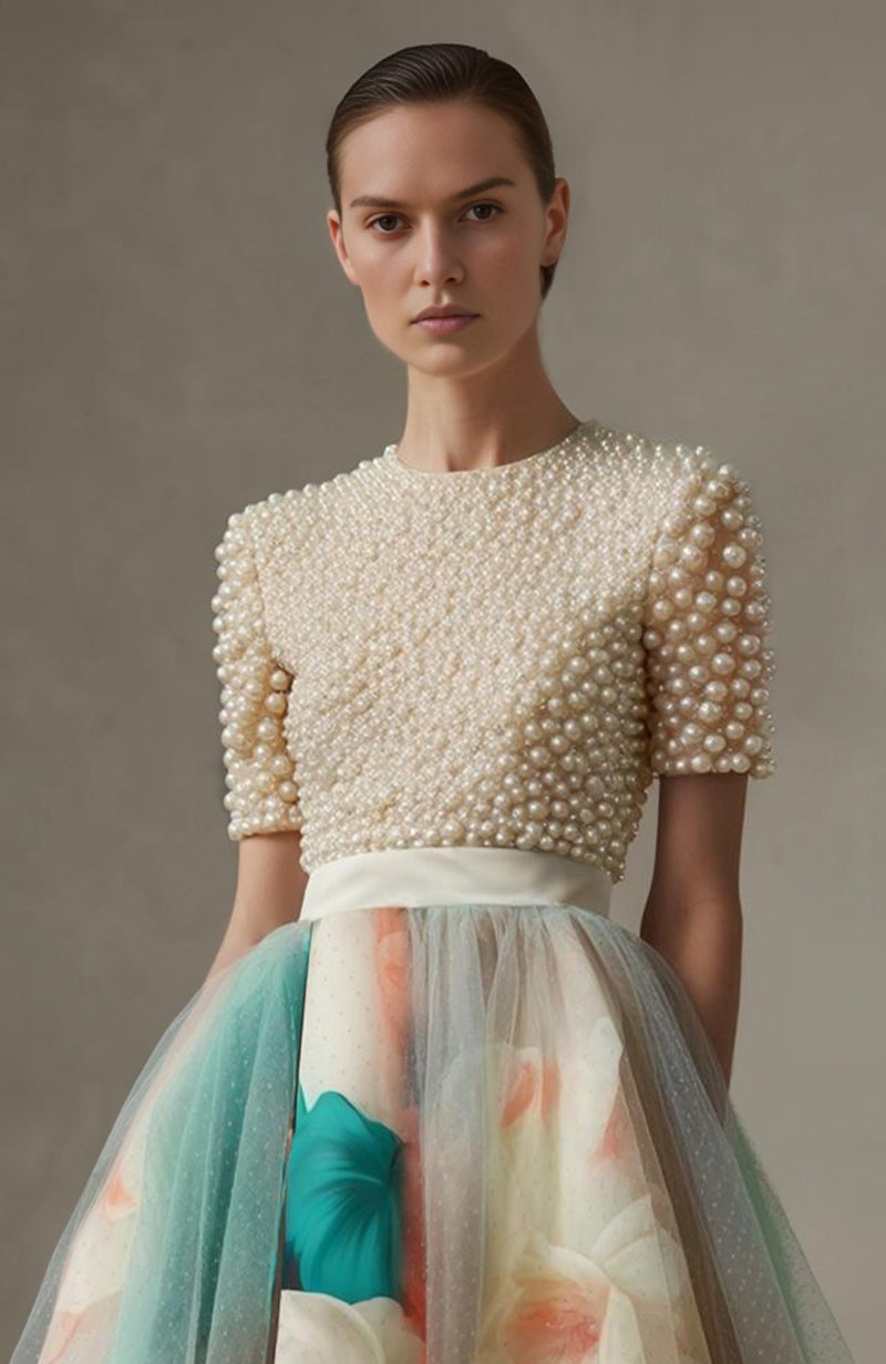 Ivory pearl-embroidered short-sleeve top paired with a high-waisted floral print A-line skirt.