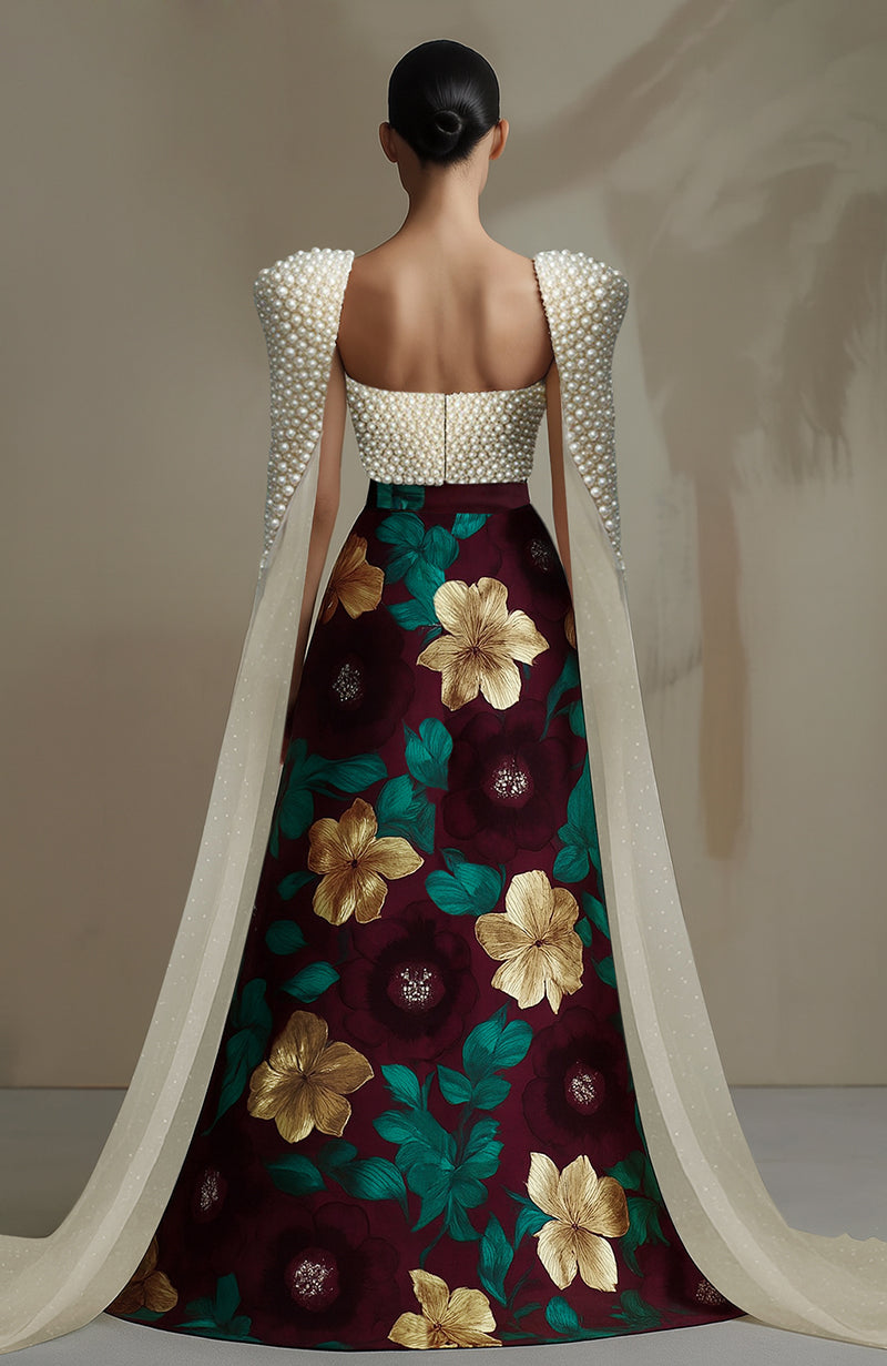 Black bustier with pearl embroidery and sheer panels paired with a floral high-slit skirt.