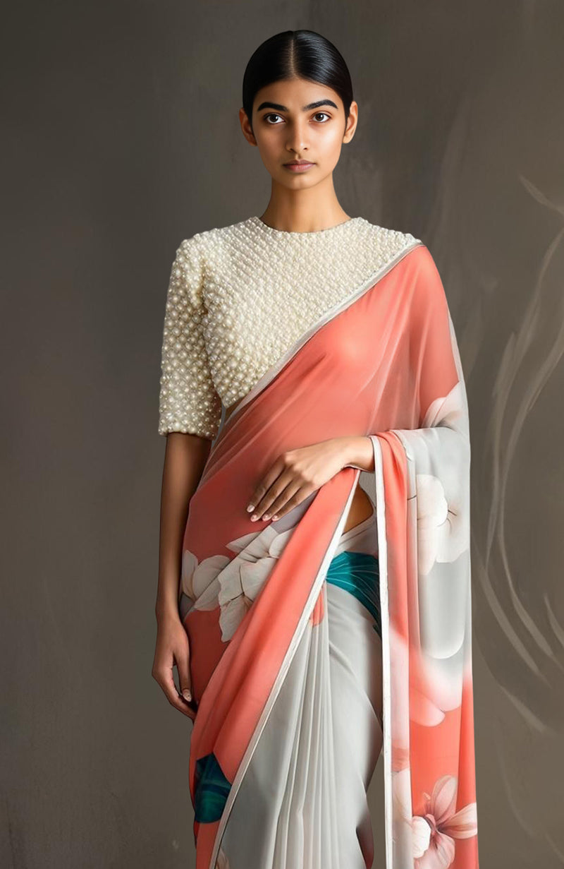 Coral ombré chiffon saree with ivory, blush, and teal florals paired with pearl-embroidered blouse.