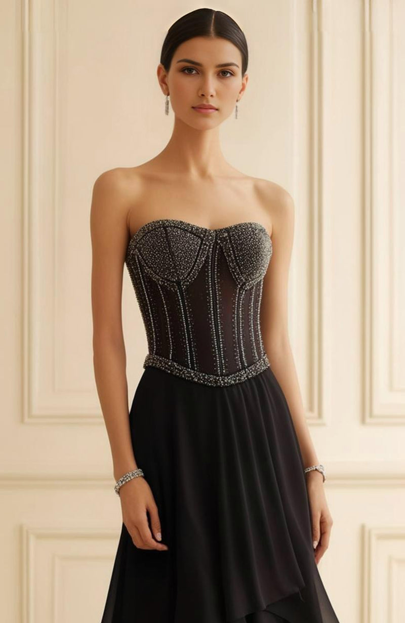 Strapless black evening gown with sheer beaded corset and flowing layered chiffon skirt.