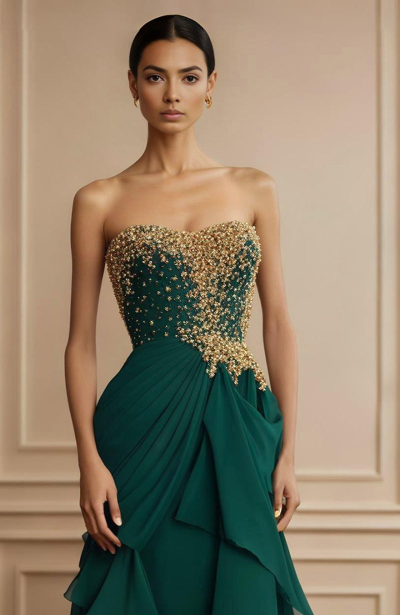Strapless emerald green gown with gold floral embroidery and asymmetrical layered skirt panels