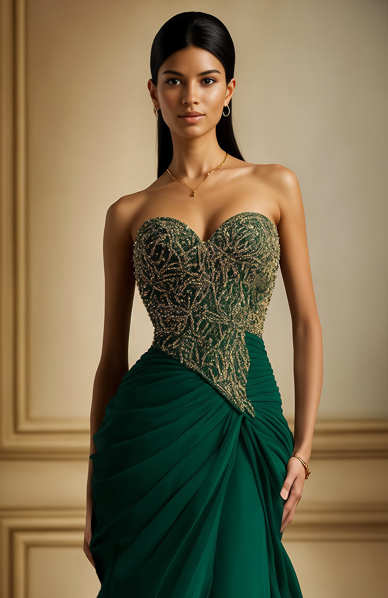 Strapless emerald green gown with gold embroidered bodice and flowing pleated skirt.