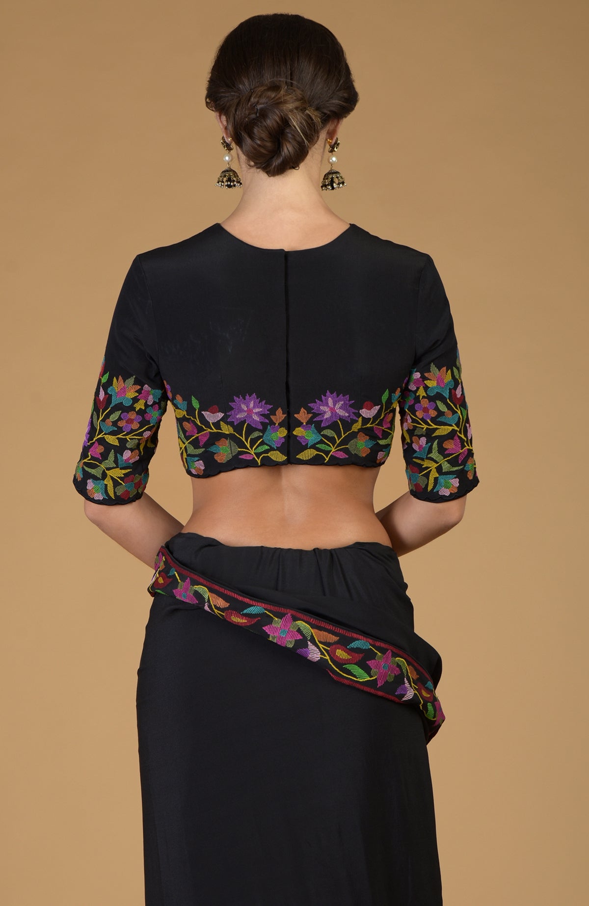 Black pure crepe silk saree with a matching blouse featuring colorful floral embroidery.