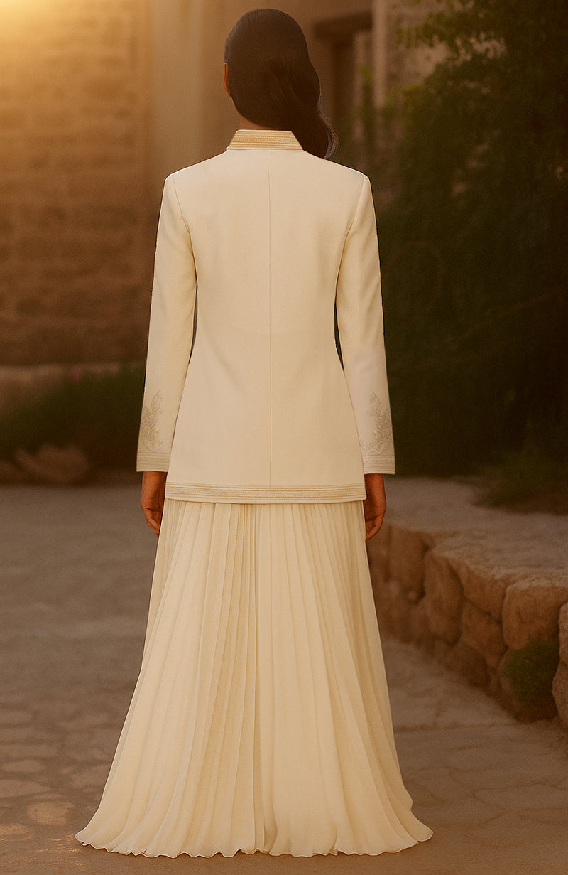Ivory nude three-piece set with embroidered jacket, crystal bralette, and pleated lehenga skirt.