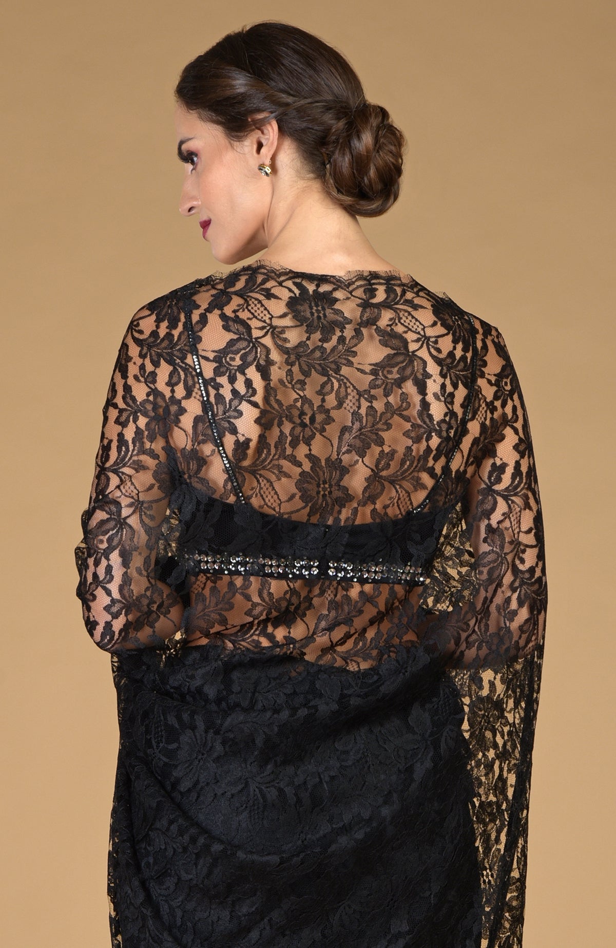 Woman in a black French Chantilly lace saree with an embellished blouse.