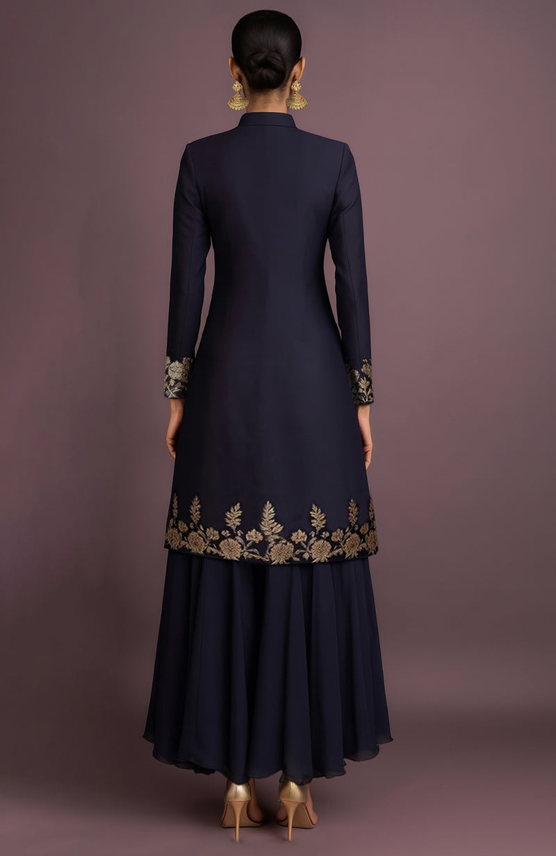 Midnight navy silk sherwani jacket with gold embroidery and matching asymmetrical high-low skirt.