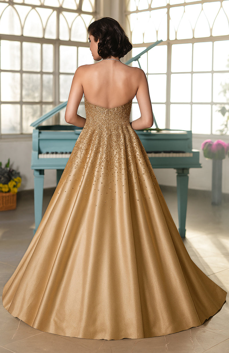 Strapless golden ball gown with crystal hand embroidery and a voluminous skirt.