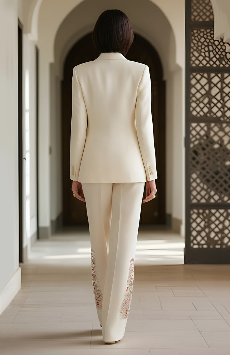 Ivory blazer and embroidered trousers with paisley motifs in gold, rose, green, and copper threads.