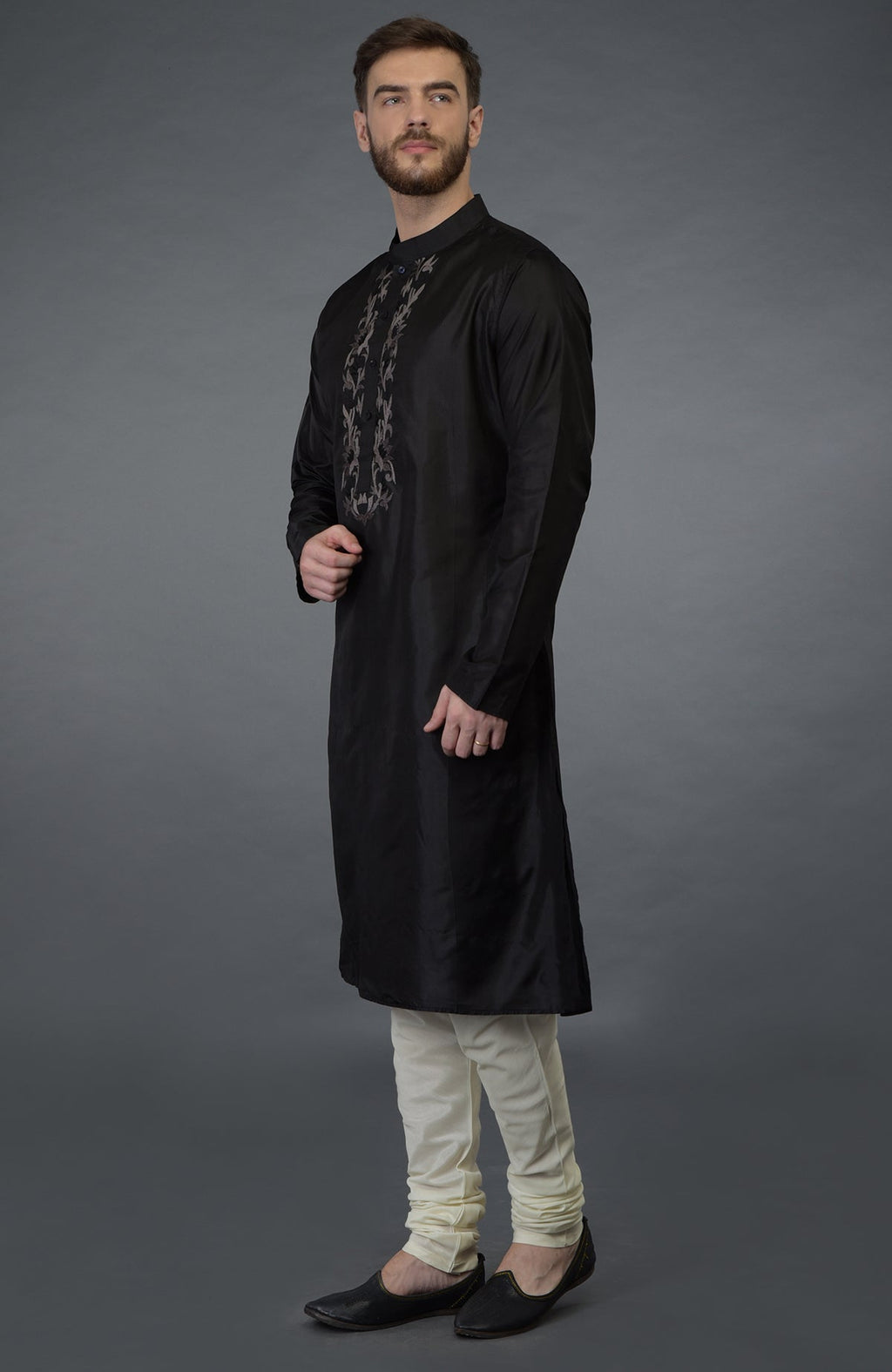 Black silk kurta with floral embroidered placket detail, paired with cream churidar and black juttis.