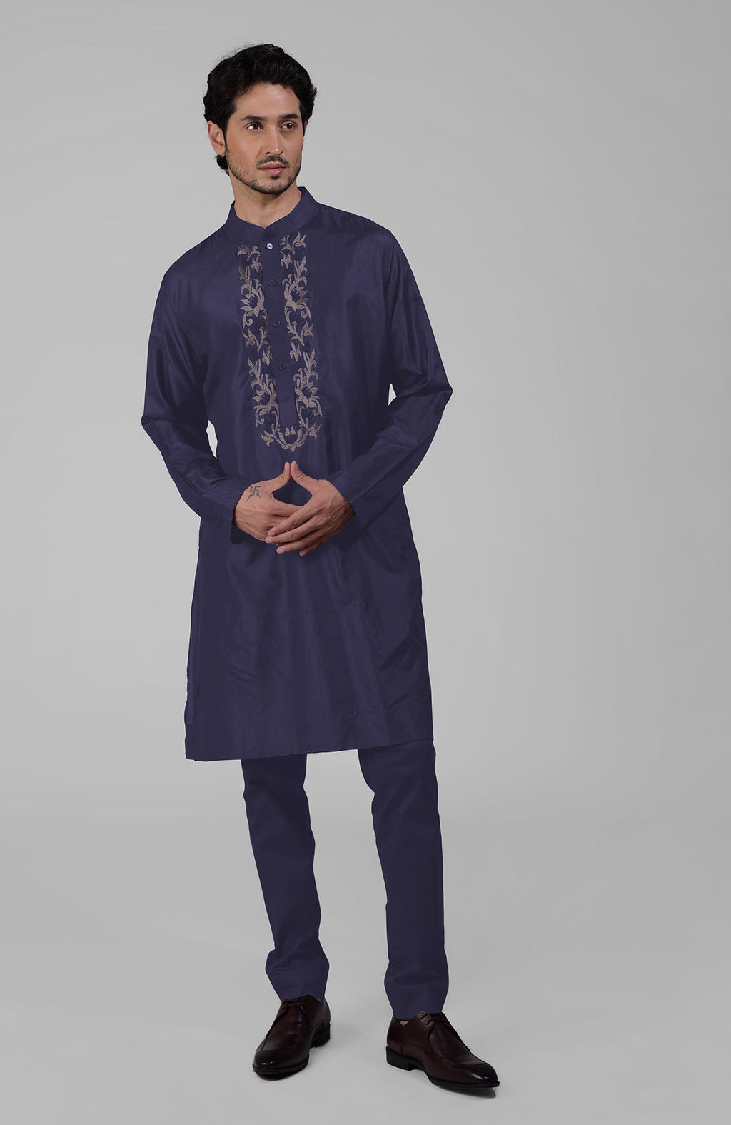 Ink blue silk kurta with floral embroidered placket detail, worn by a man.
