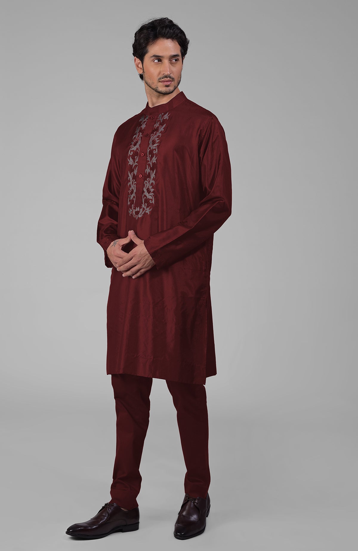 Maroon silk kurta with floral embroidered placket detail, paired with matching pants and brown shoes.