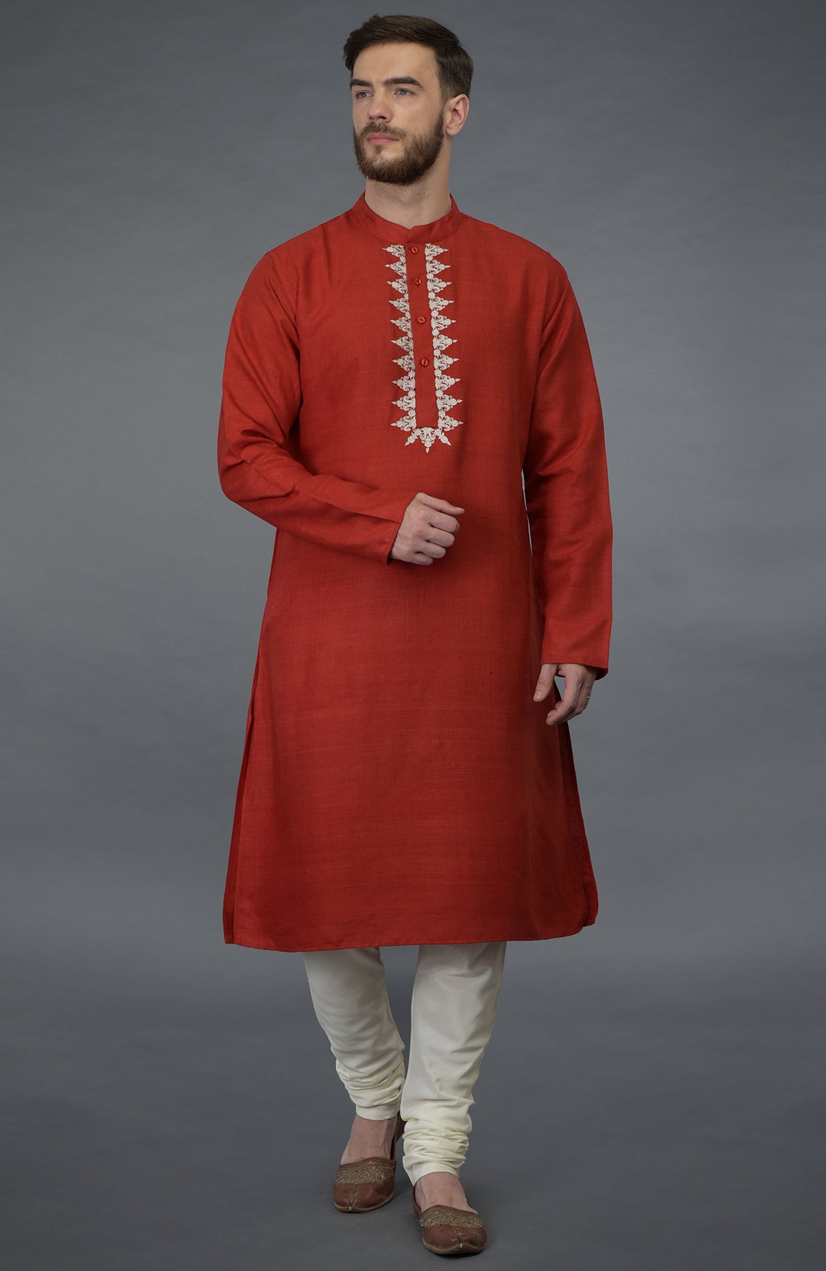 A man models a red pure silk kurta with floral embroidery and ivory cotton-silk lowers.